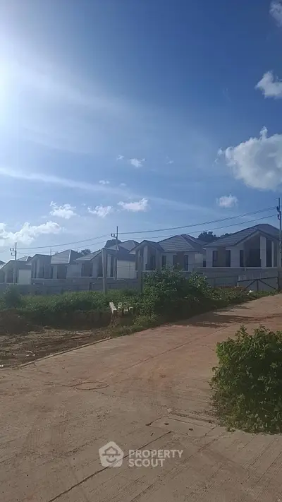 Modern residential houses under clear blue sky in a serene neighborhood.