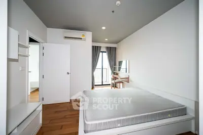 Modern bedroom with minimalist design and balcony view, featuring wooden flooring and air conditioning.