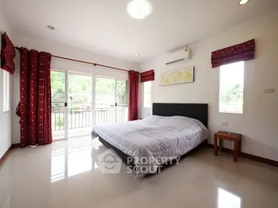 Spacious bedroom with large windows and balcony access in modern home.