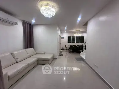 Spacious modern living room with elegant chandelier and cozy sectional sofa