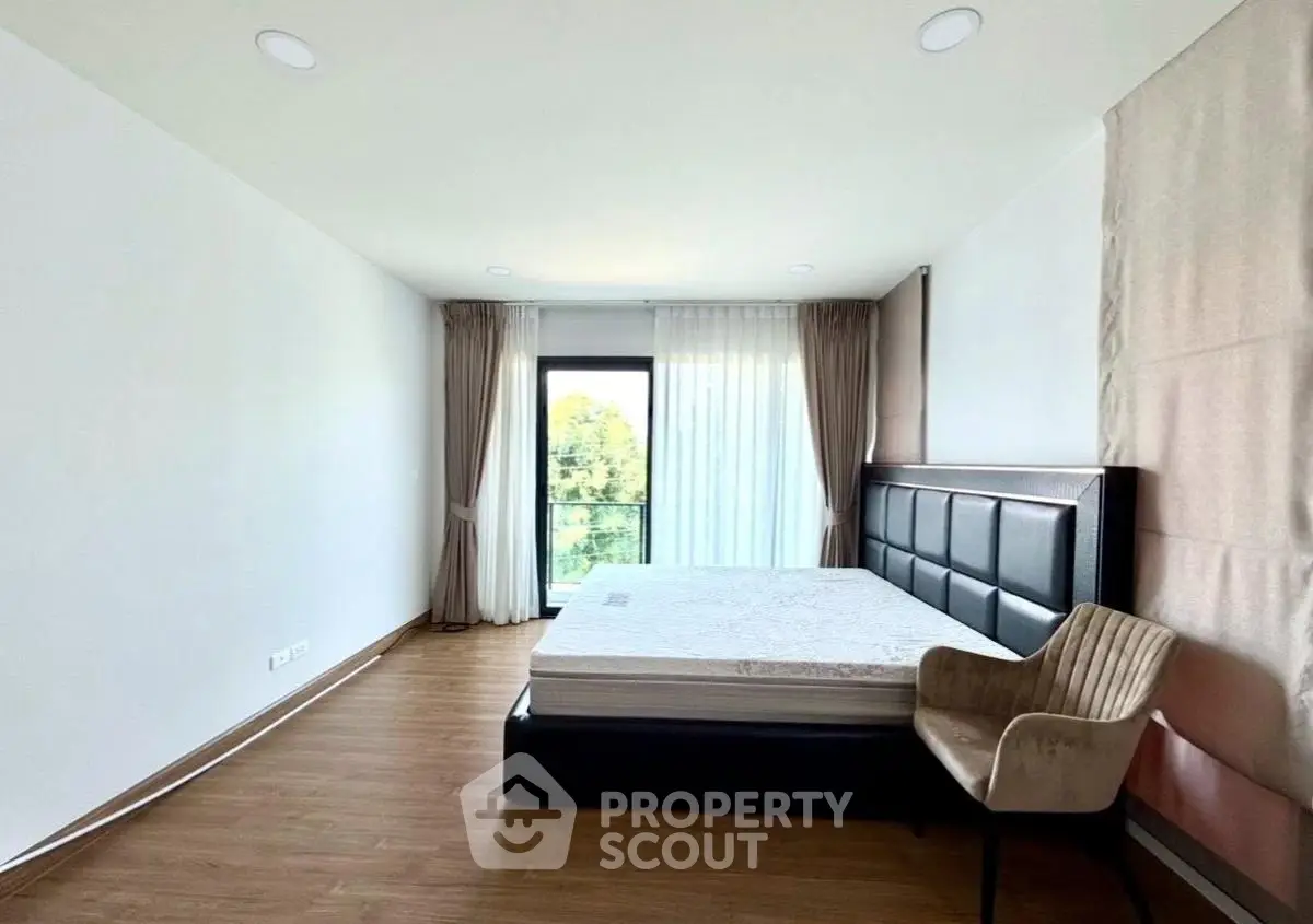 Spacious bedroom with large window and modern furnishings