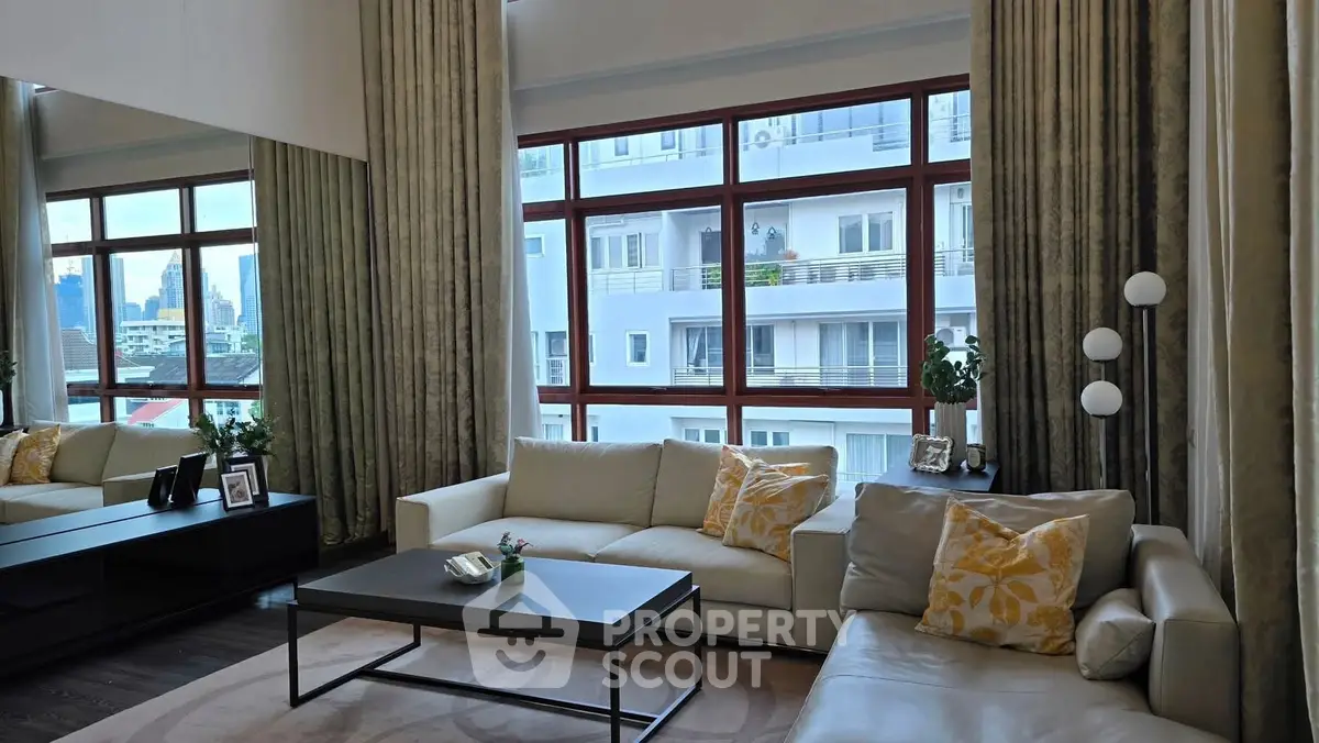 Luxurious living room with large windows and elegant decor in a modern apartment.