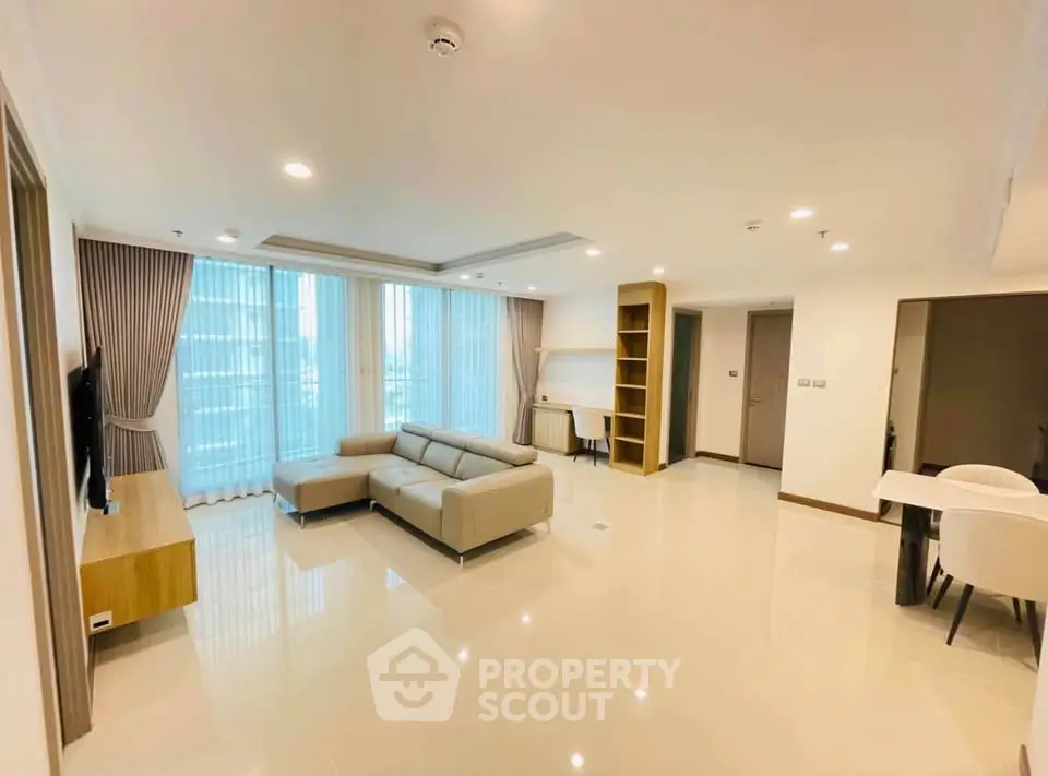 Spacious modern living room with elegant furniture and natural light in a high-rise apartment.