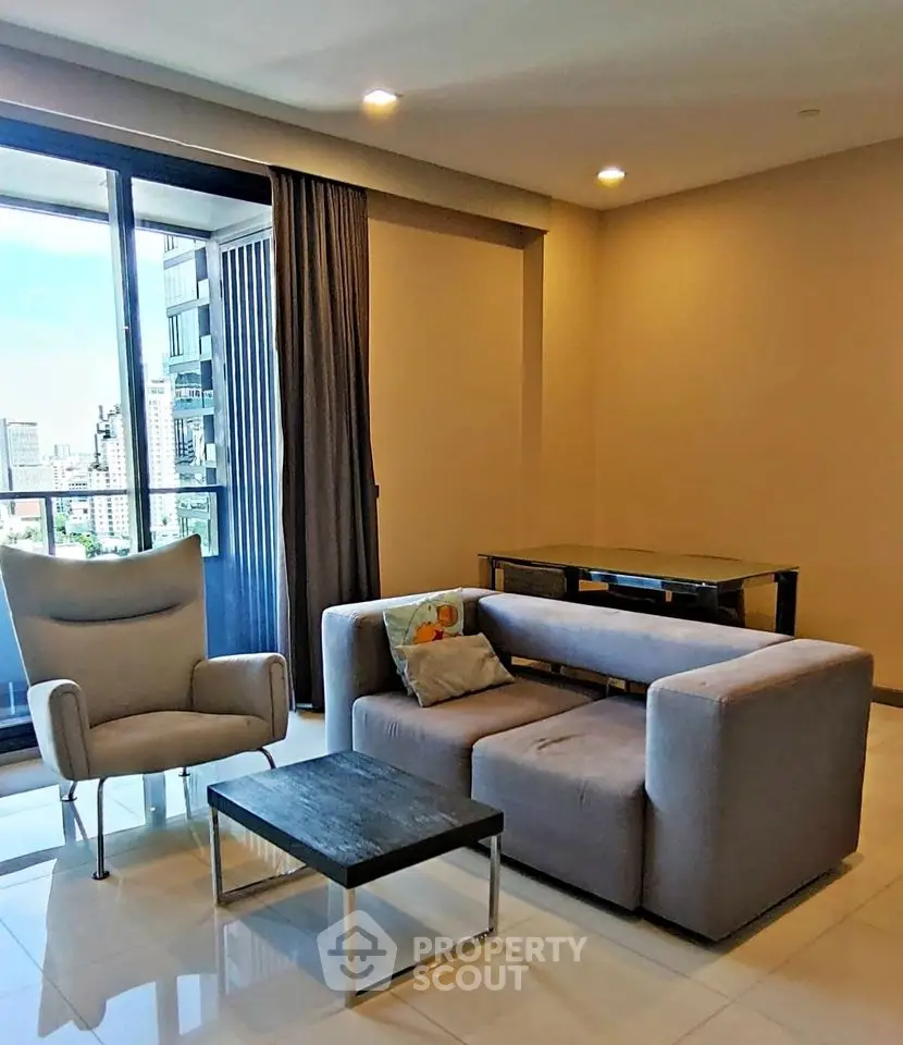 Modern living room with city view, stylish furniture, and large windows for natural light.