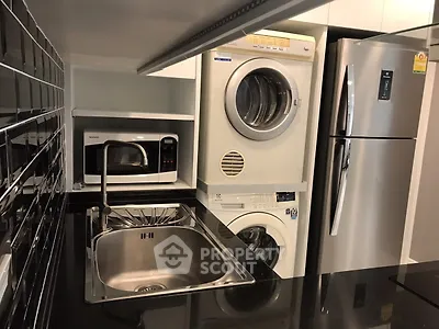 Modern kitchen with sleek appliances including fridge, microwave, and washer-dryer combo.
