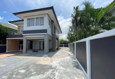 Modern two-story house with spacious driveway and lush greenery