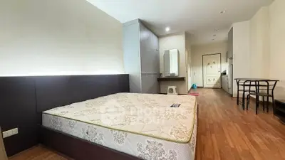 Spacious studio apartment with modern furnishings and wooden flooring, ideal for urban living.