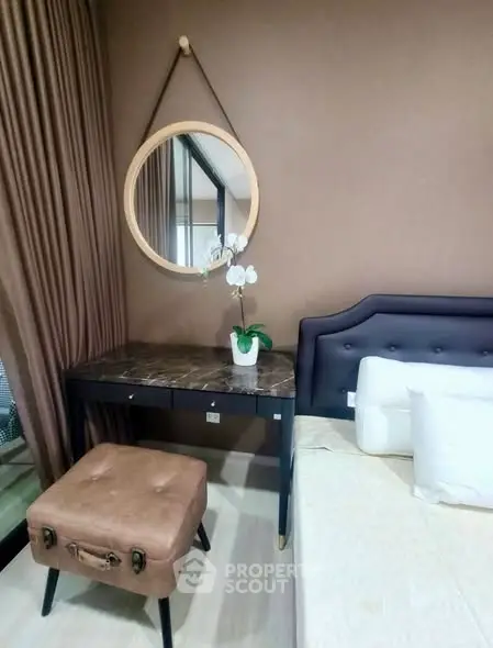 Stylish bedroom with elegant decor and modern furniture, featuring a chic vanity and plush seating.