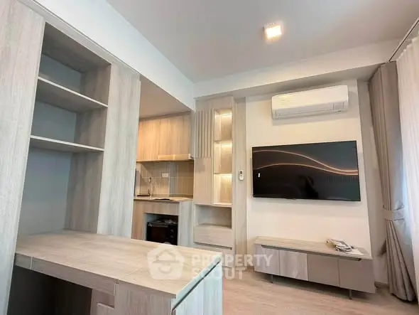 Modern living room with built-in shelves, air conditioning, and flat-screen TV in a stylish apartment.