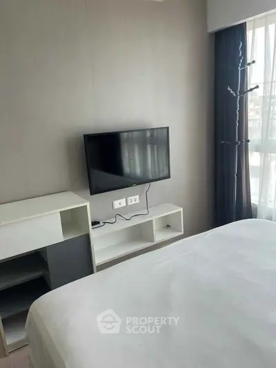 Modern bedroom with wall-mounted TV and sleek furniture design