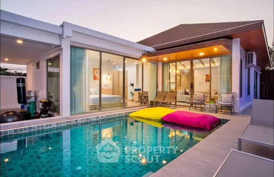 Luxurious modern villa with private pool and spacious outdoor area at sunset.
