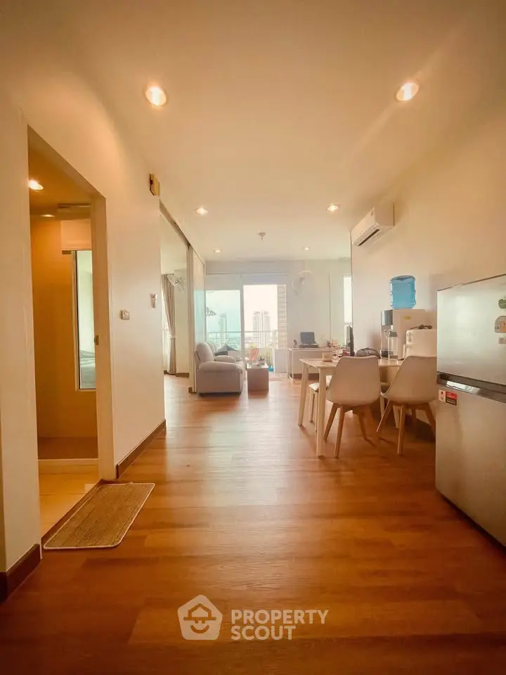 Spacious open-plan living room with modern furnishings and city view.