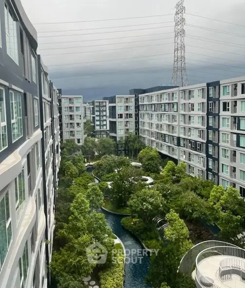 Stunning view of modern apartment complex with lush gardens and water features.