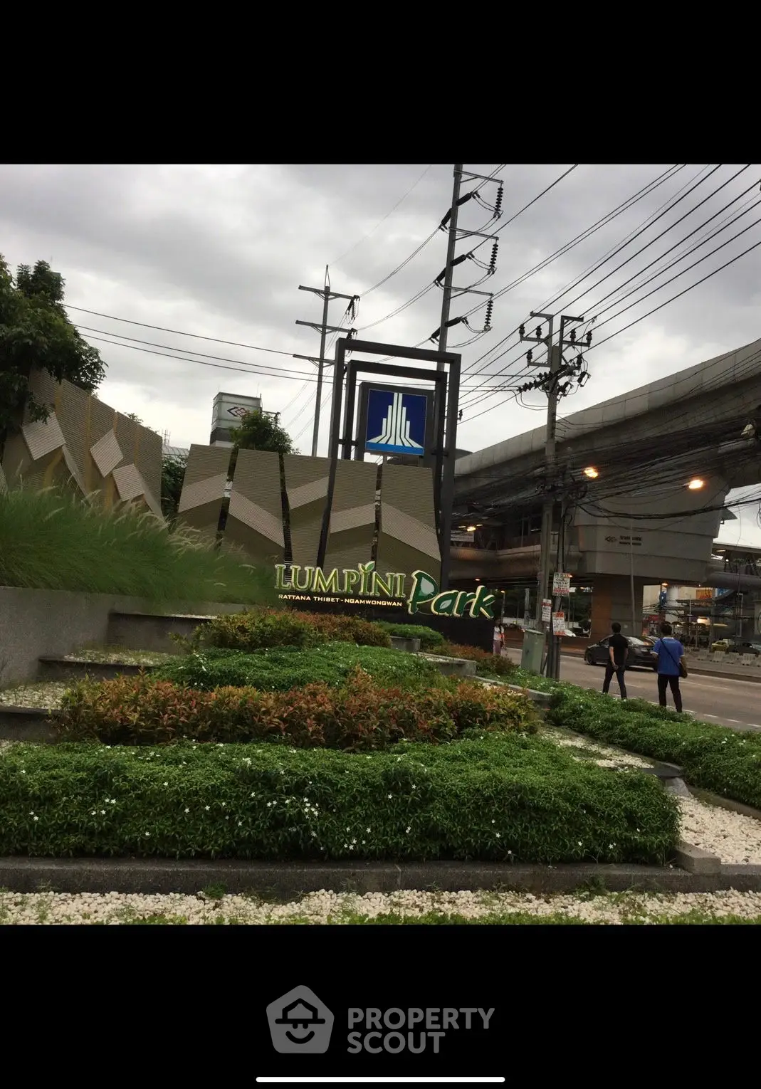 Lush greenery at Lumpini Park entrance with urban backdrop