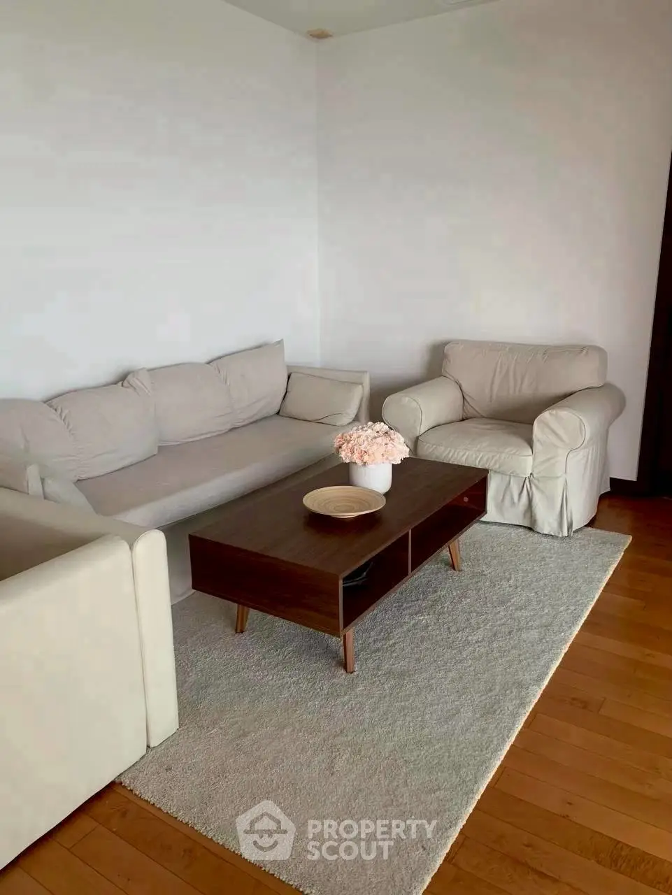 Cozy living room with modern furniture and wooden flooring, perfect for relaxation.