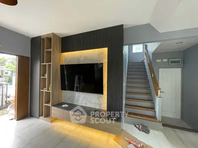 Modern living room with stylish TV wall and staircase