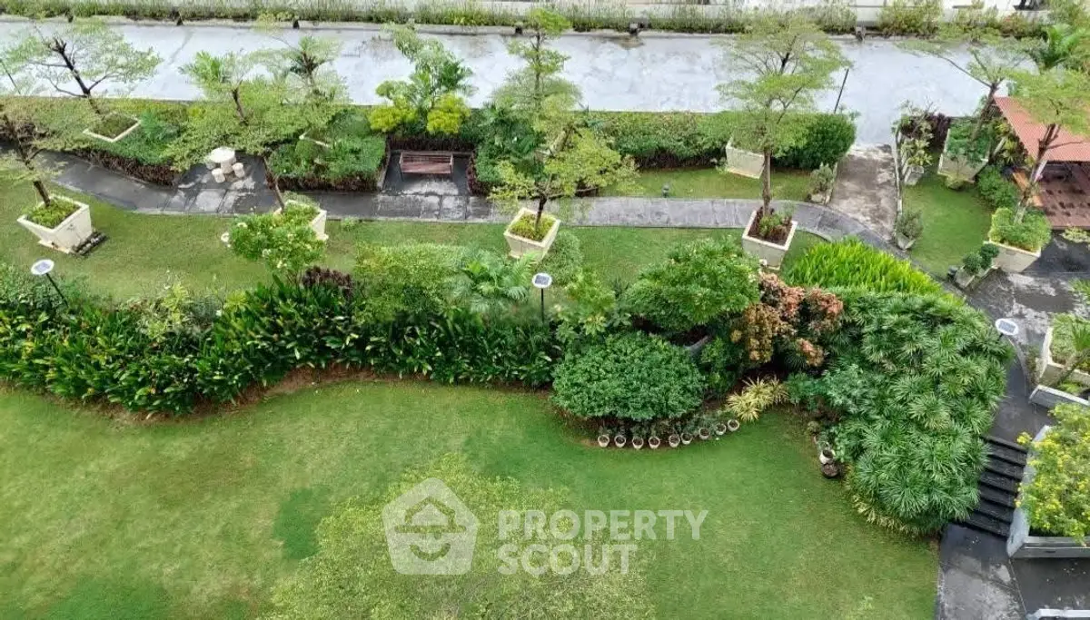 Lush green garden with pathways and seating areas in a serene residential complex.