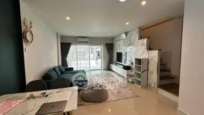Modern living room with stylish decor and open layout, featuring a cozy sofa and elegant marble accents.