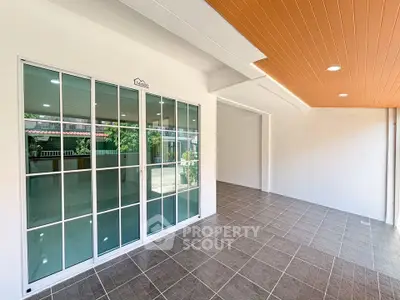 Spacious modern patio with sliding glass doors and stylish ceiling design