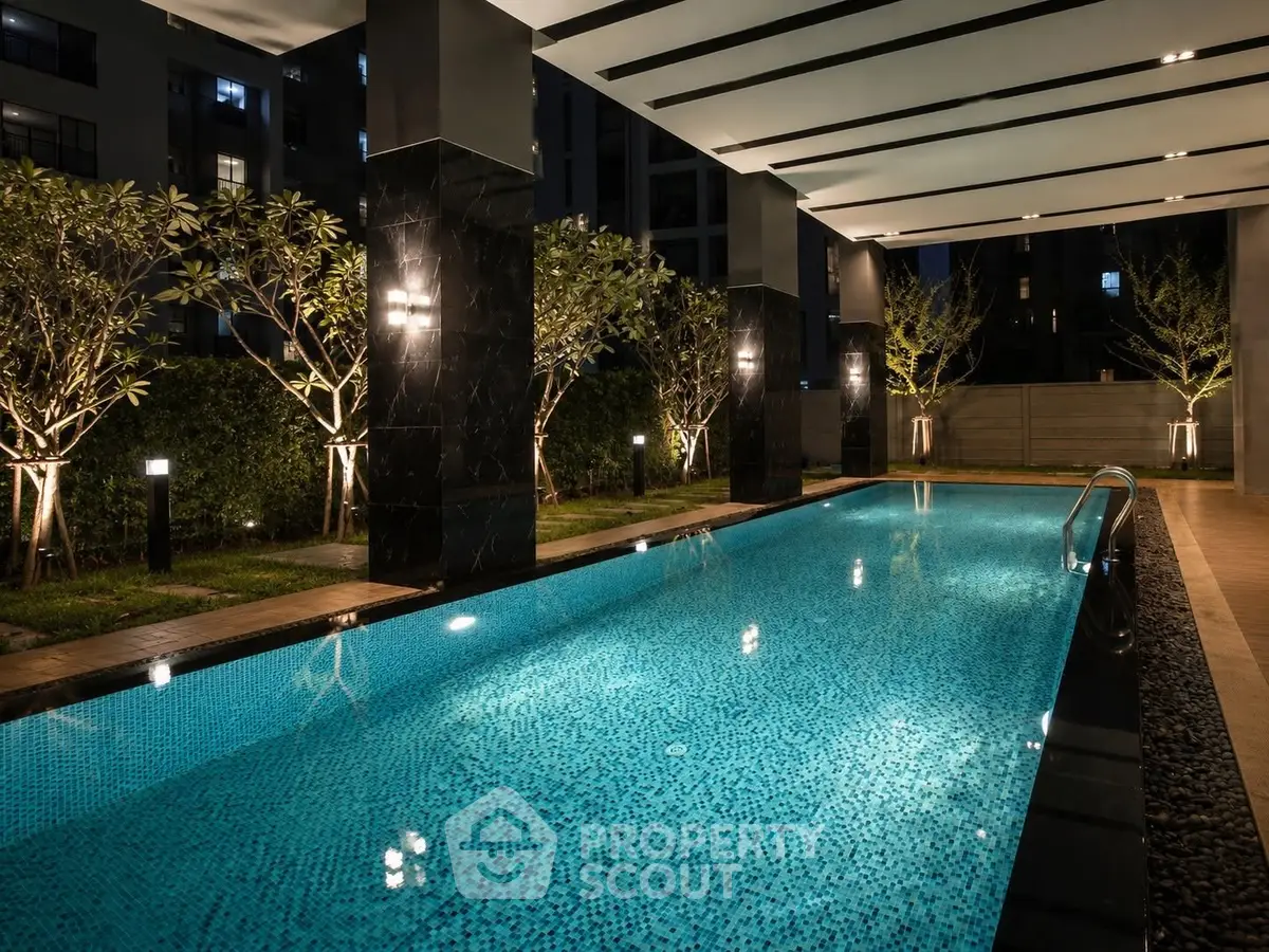 Luxurious indoor swimming pool with ambient lighting in modern residential complex.