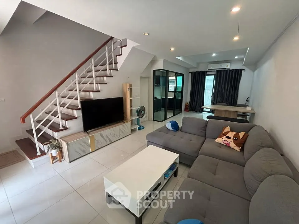 Spacious living room with modern decor and stylish staircase
