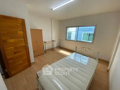 Spacious bedroom with natural light and wooden flooring