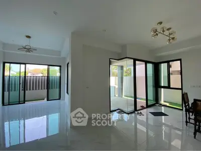 Spacious modern living room with large windows and elegant lighting fixtures