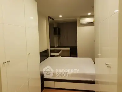 Modern bedroom with sleek white wardrobes and cozy ambiance.