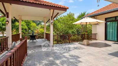 Spacious terrace with tiled flooring and lush garden view in a modern home.