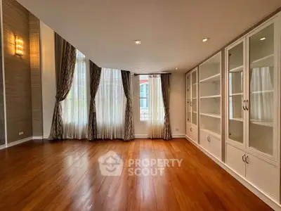 Spacious living room with elegant hardwood floors and large windows for natural light.