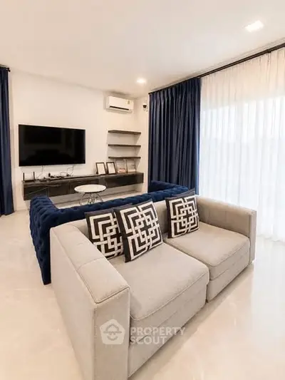 Modern living room with stylish sofa, TV, and elegant decor