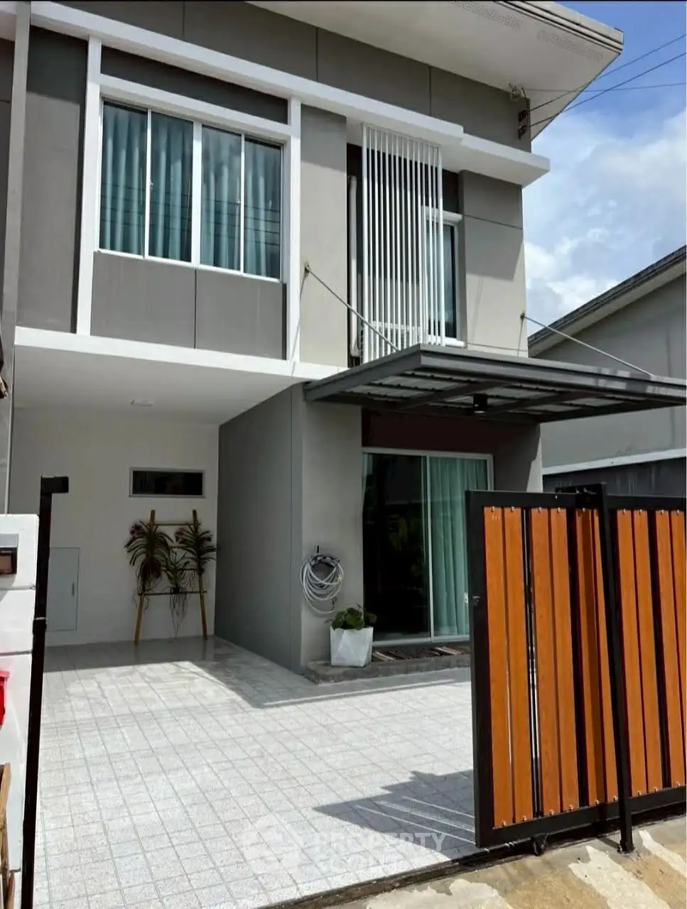 Modern two-story house with sleek facade and spacious driveway, perfect for contemporary living.