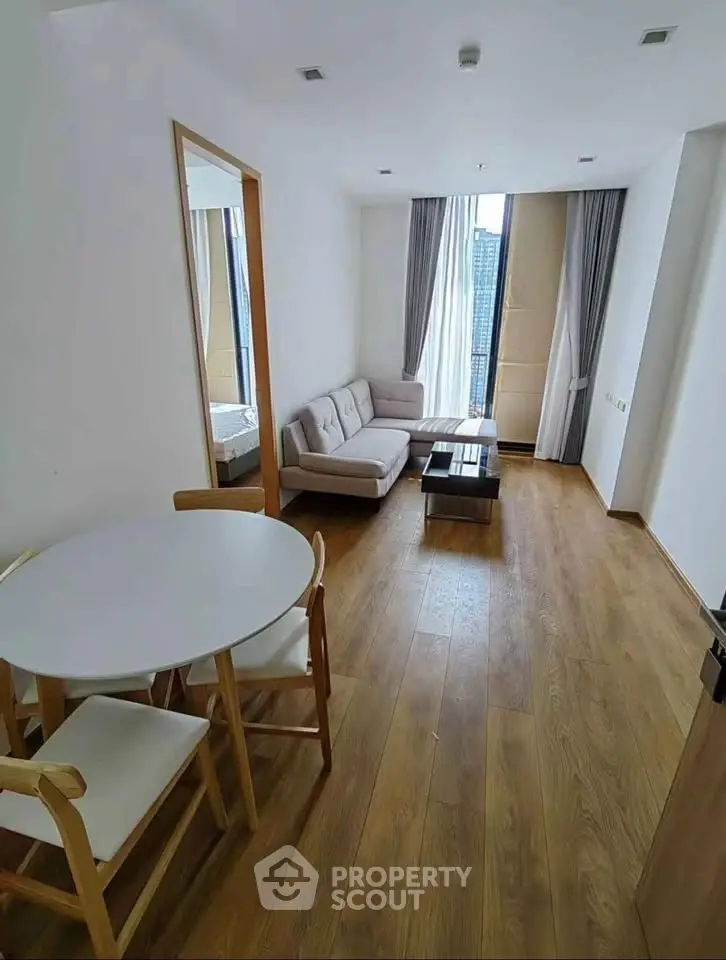 Modern living room with wooden flooring and stylish furniture in a high-rise apartment.