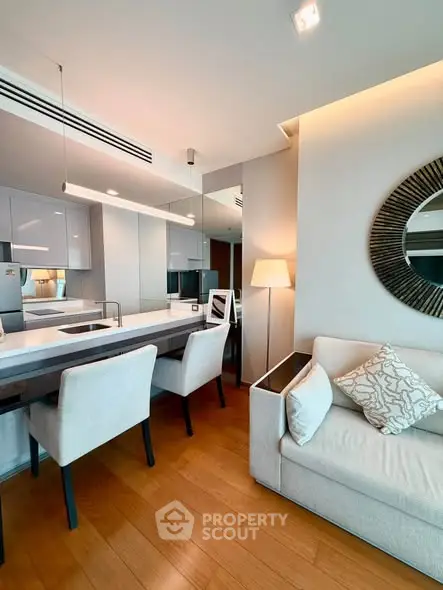 Modern open-layout kitchen and living area with stylish decor and wooden flooring.