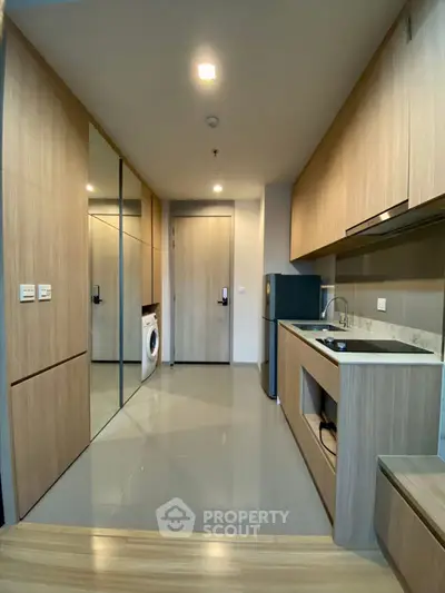 Modern kitchen with sleek cabinetry and integrated appliances in a stylish apartment.