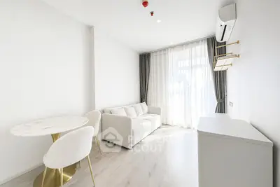 Bright modern living room with elegant furniture and large window, perfect for relaxation.