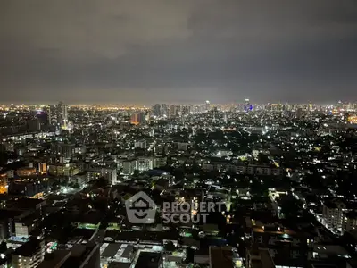 Stunning cityscape view from high-rise apartment at night, showcasing vibrant urban lights.