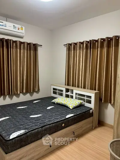 Cozy bedroom with modern furnishings and ample natural light.