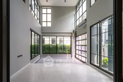Spacious modern living room with high ceilings and large windows for natural light.