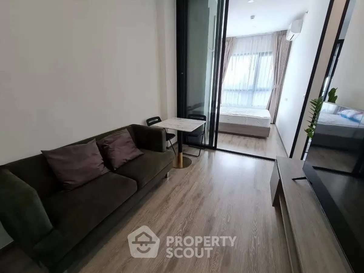 Modern living room with cozy sofa and view into bedroom, perfect for urban living.