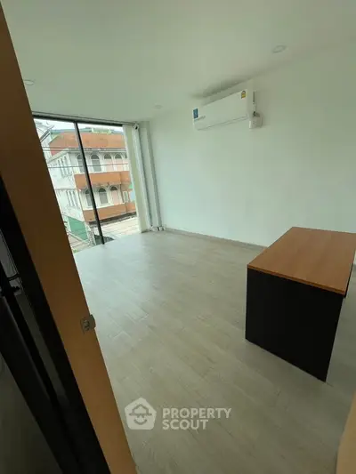 Spacious study room with large window and modern air conditioning unit
