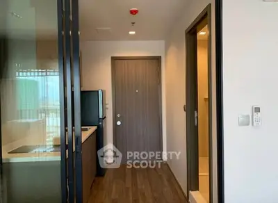 Modern apartment entrance with sleek kitchen and wooden flooring