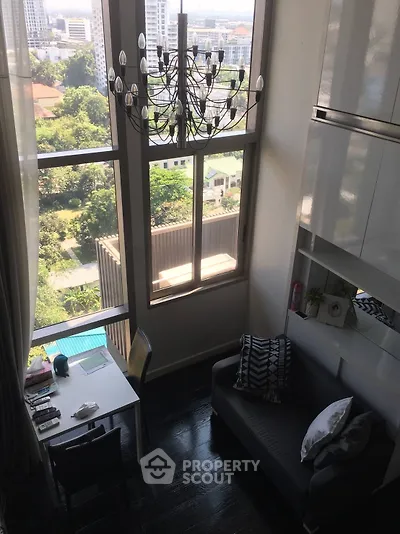 Stunning high-ceiling living room with large windows and city view, featuring elegant chandelier and modern decor.