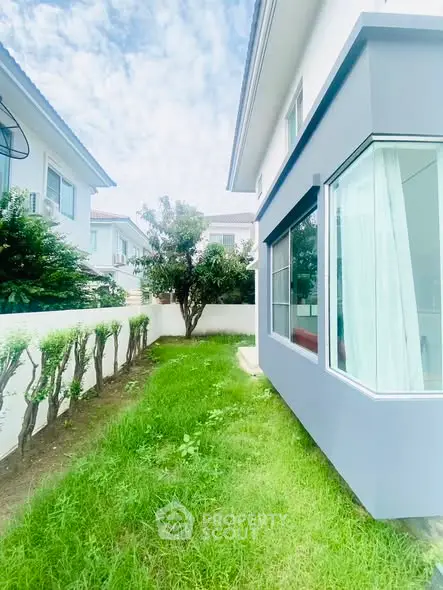 Charming residential property with lush green garden and modern exterior design.