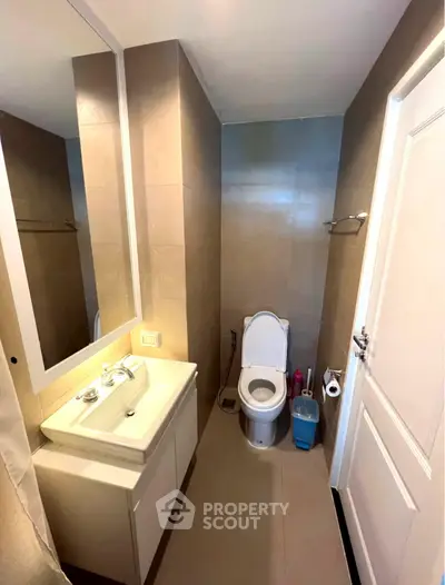 Modern bathroom with sleek fixtures and neutral tones, featuring a compact design for efficient space use.