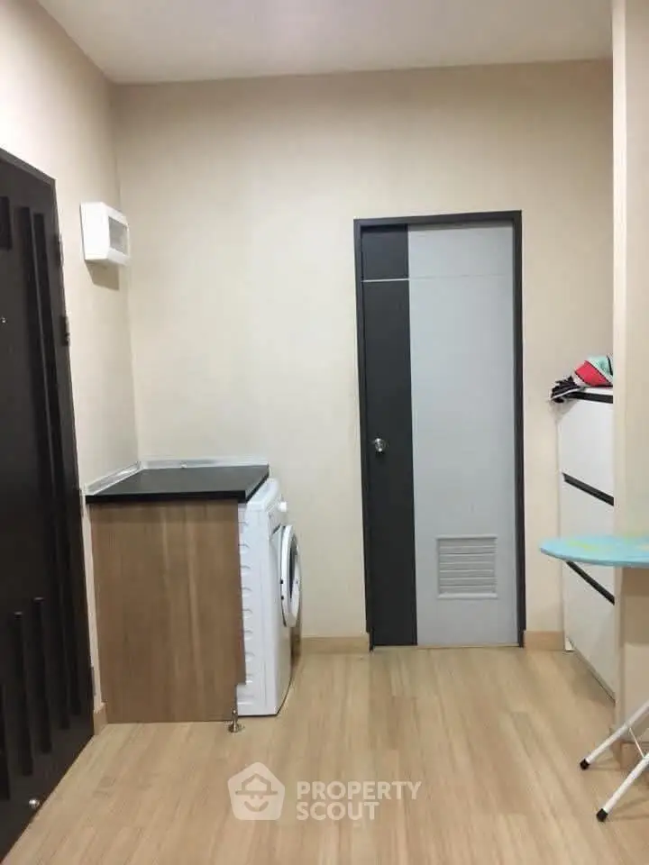 Compact laundry area with washing machine and storage in modern apartment.