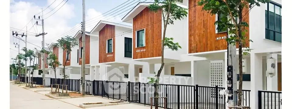 Modern townhouse row with sleek design and wooden accents in a suburban neighborhood.