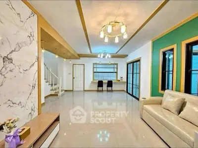 Spacious modern living room with elegant lighting and marble accents, perfect for stylish living.