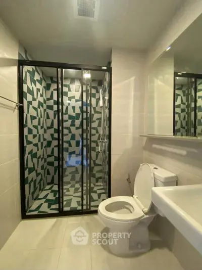 Modern bathroom with geometric shower design and sleek fixtures.