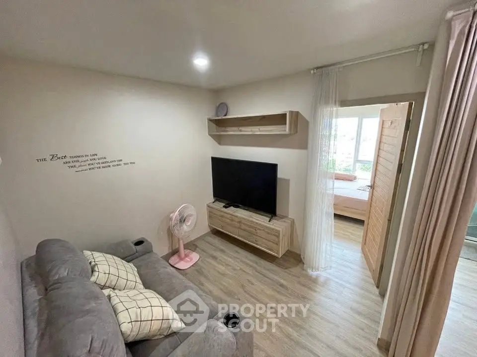 Cozy living room with modern decor and open view to bedroom, perfect for urban living.